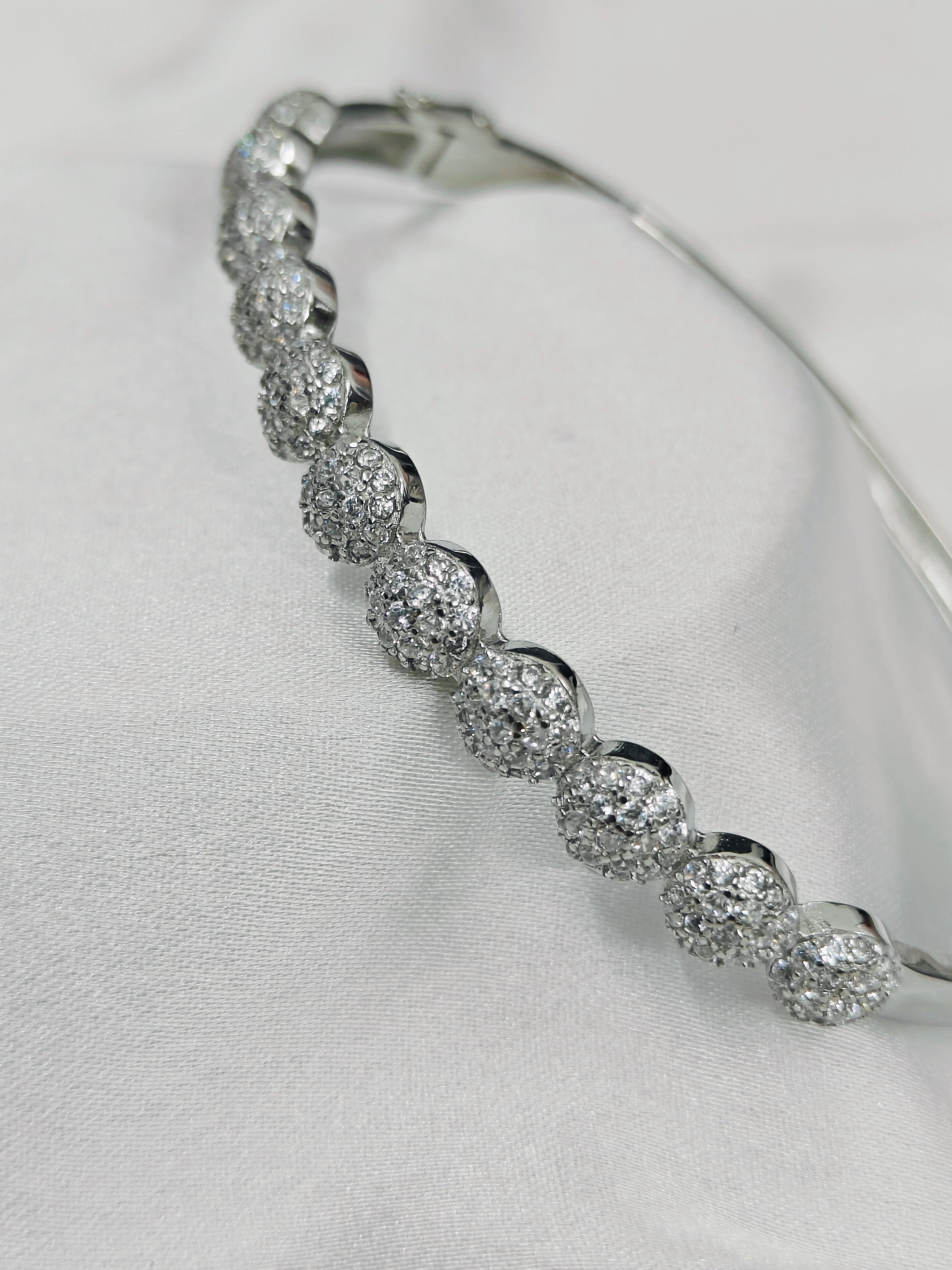 Silver bracelet with clear stones on a light gray background